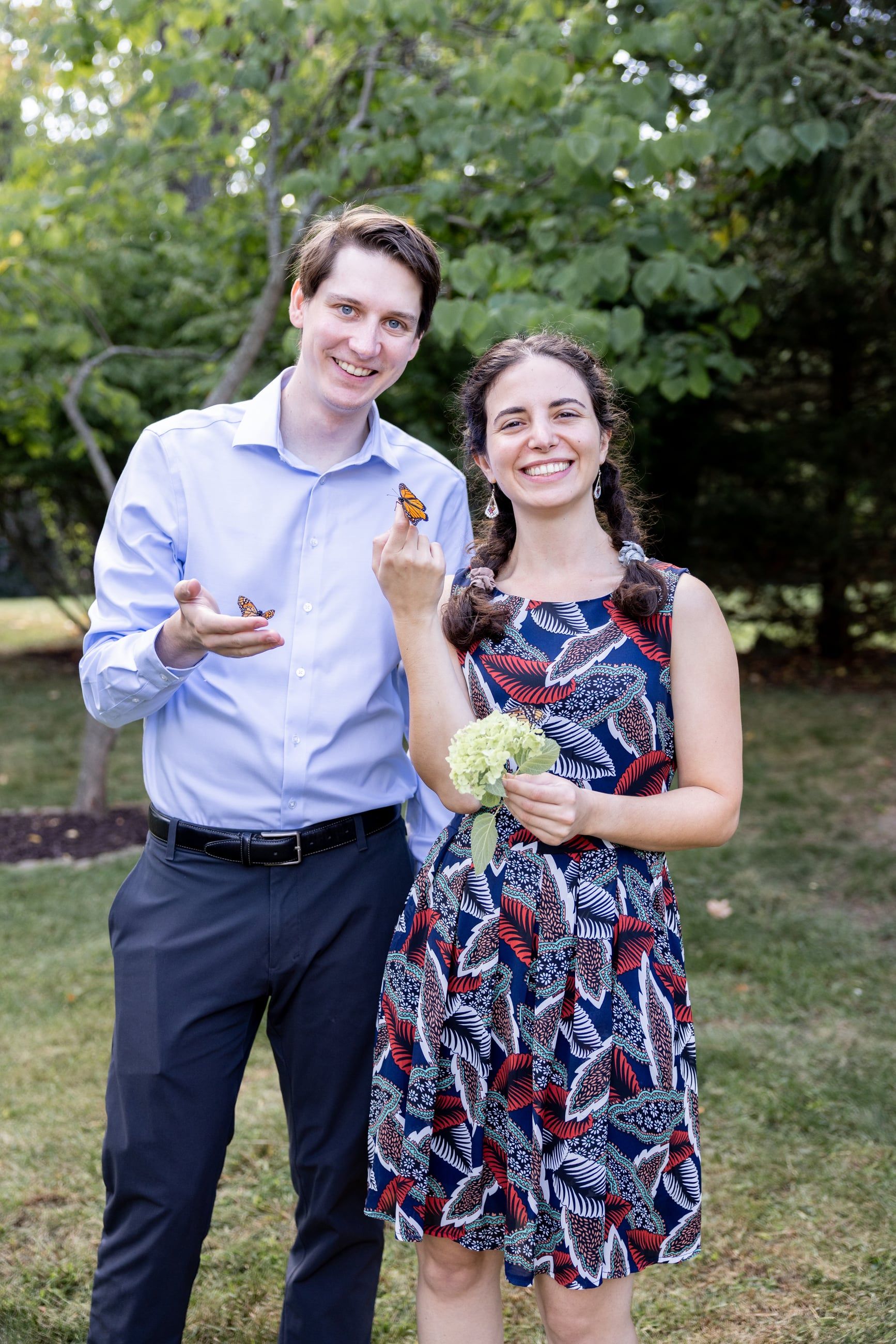 Katherine and Johnny in a garden, a butterfly perched on each of their hands