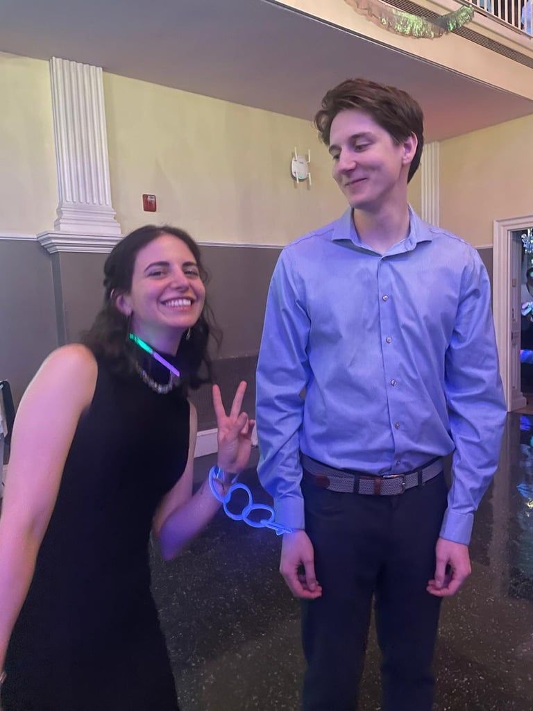 Katherine and Johnny at a party, glow sticks around their necks