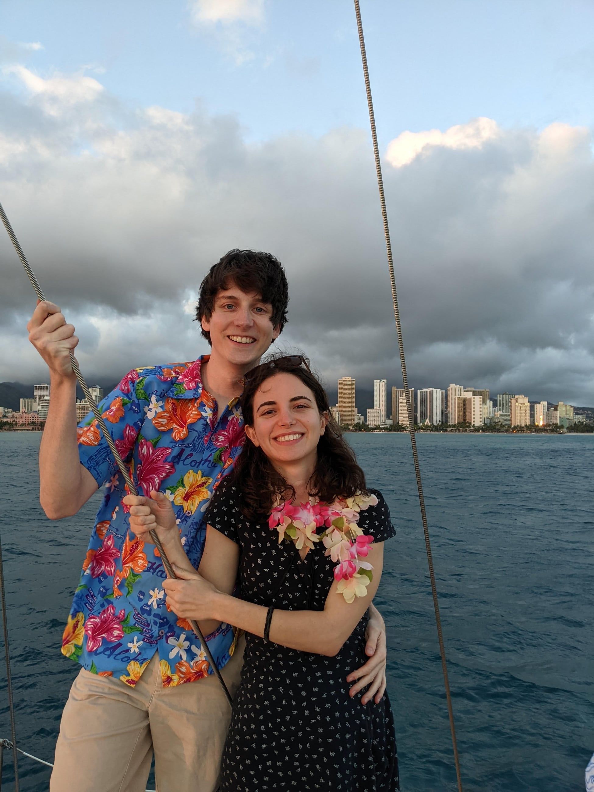 Katherine and Johnny on a sailboat in Hawaii, in leis and a flowered shirt