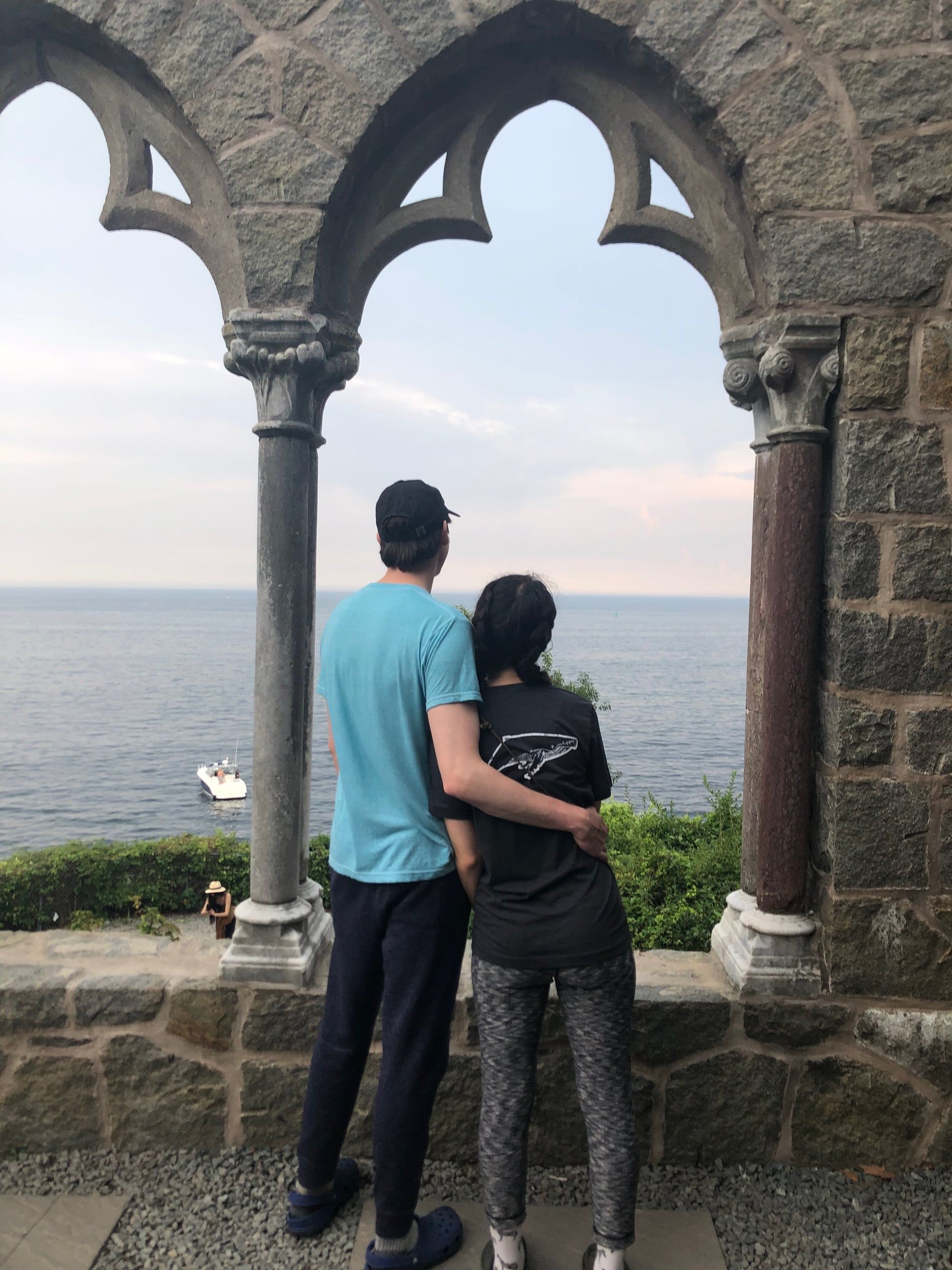 Katherine and Johnny under a stone arch, looking out over the water