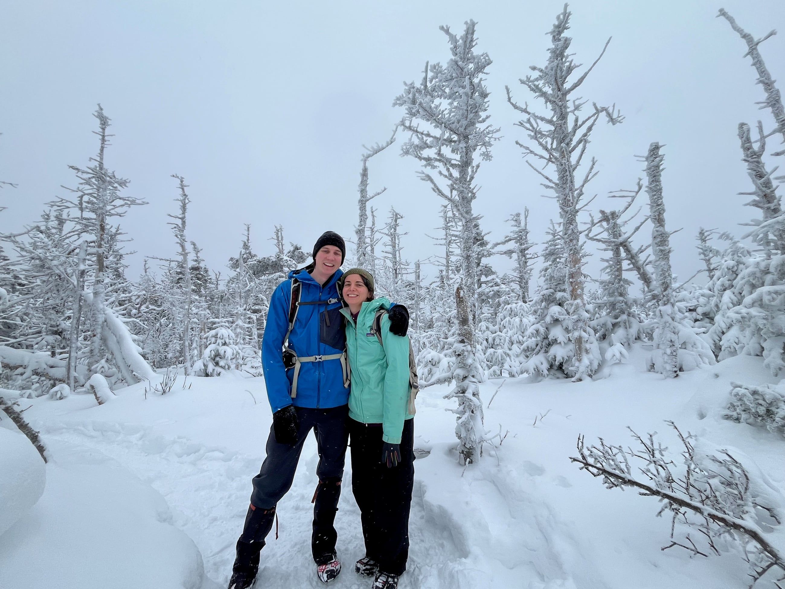 Katherine and Johnny among snow-covered trees on a winter hike